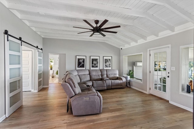 living room with wood ceiling, lofted ceiling with beams, a barn door, light hardwood / wood-style flooring, and ceiling fan