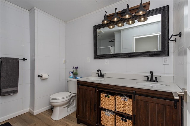 bathroom featuring tile walls, vanity, hardwood / wood-style flooring, ornamental molding, and toilet