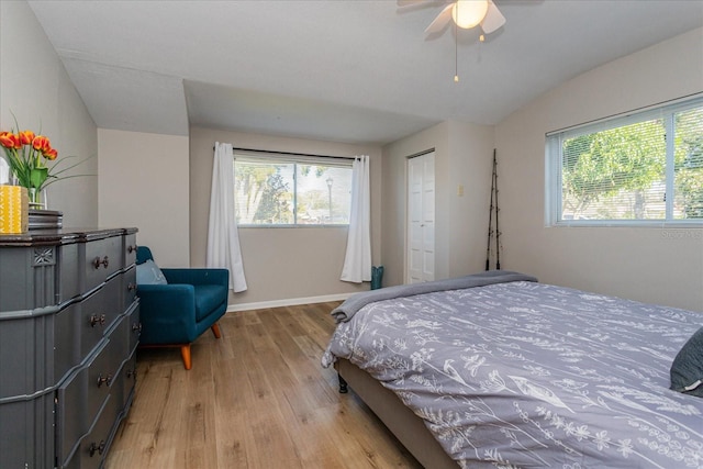 bedroom with ceiling fan, light hardwood / wood-style flooring, and a closet