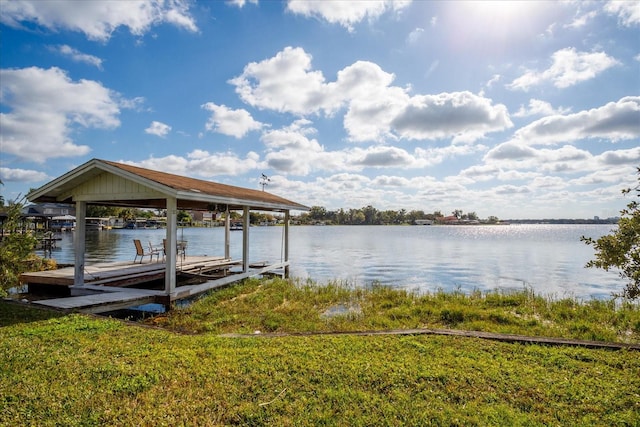 view of dock featuring a lawn and a water view