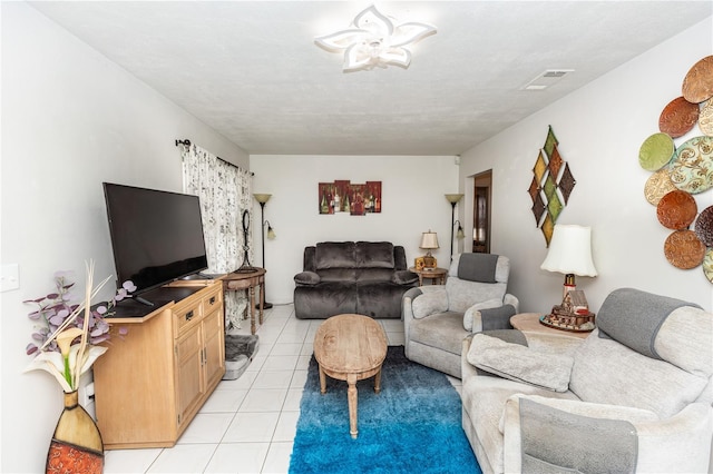 living room featuring a textured ceiling and light tile patterned floors