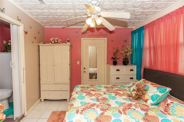 bedroom with ceiling fan, ensuite bathroom, and light tile patterned floors