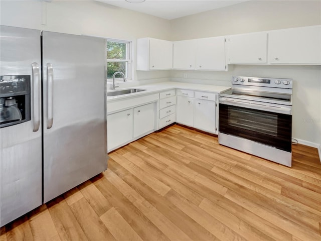 kitchen featuring appliances with stainless steel finishes, light wood-type flooring, sink, and white cabinets