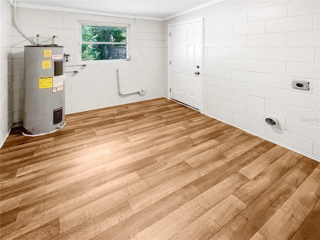 clothes washing area featuring ornamental molding, wood-type flooring, and water heater