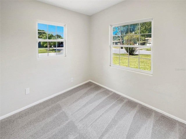 carpeted spare room featuring a healthy amount of sunlight