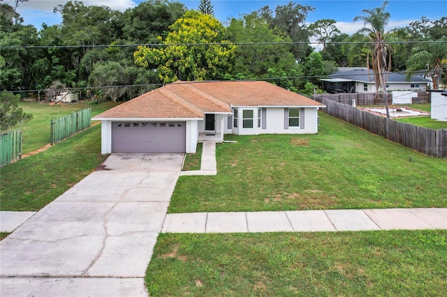 view of front of home with a front yard and a garage