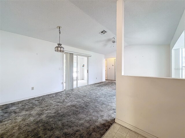 unfurnished room with light carpet, a textured ceiling, ceiling fan with notable chandelier, and vaulted ceiling