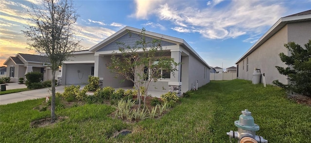 1007 Theodore St, Davenport, FL 33837 - view of front facade featuring a garage, driveway, a front yard, and stucco siding