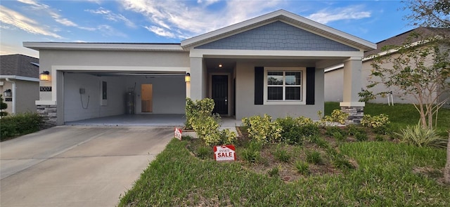 1007 Theodore St, Davenport, FL 33837 - view of front of house featuring a garage, water heater, stucco siding, and concrete driveway