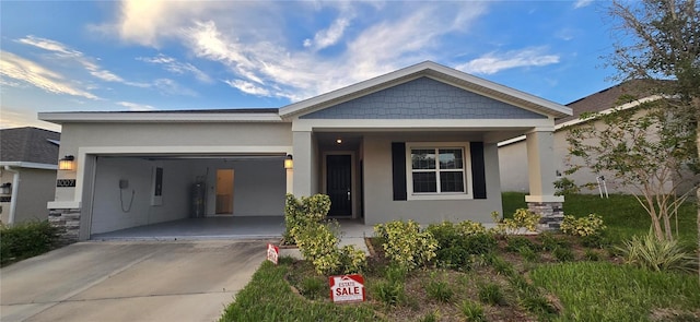1007 Theodore St, Davenport, FL 33837 - view of front of property featuring an attached garage, driveway, stone siding, and stucco siding