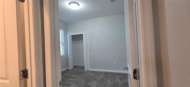 walk in closet with dark colored carpet