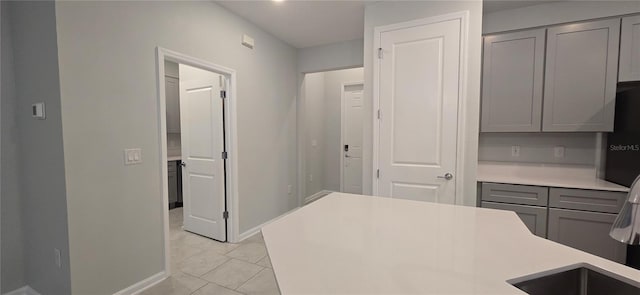 kitchen with gray cabinetry and light tile patterned floors