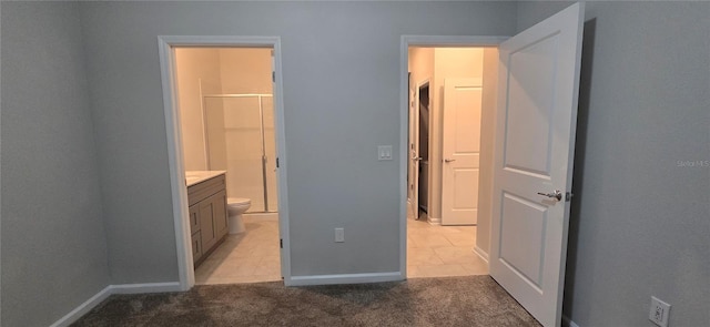 carpeted bedroom featuring ensuite bathroom and a walk in closet