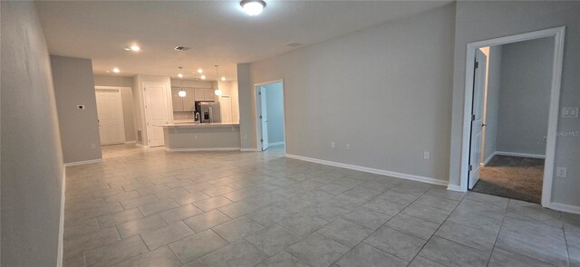 1007 Theodore St, Davenport, FL 33837 - unfurnished living room with baseboards, tile patterned flooring, and recessed lighting