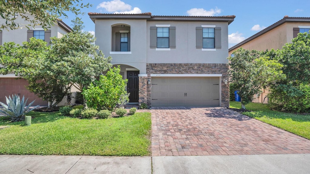 mediterranean / spanish house featuring a front yard and a garage