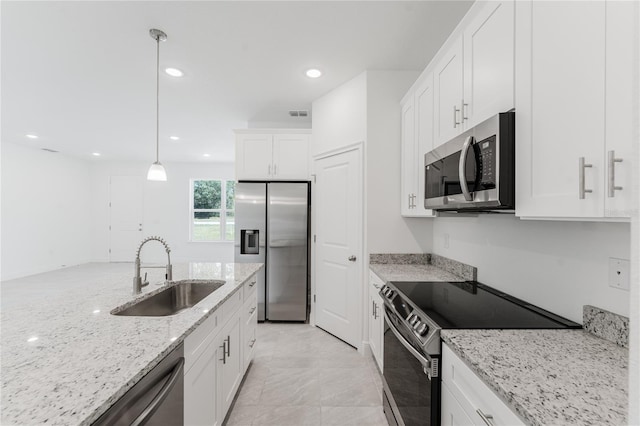 kitchen with stainless steel appliances, sink, light stone countertops, white cabinetry, and decorative light fixtures