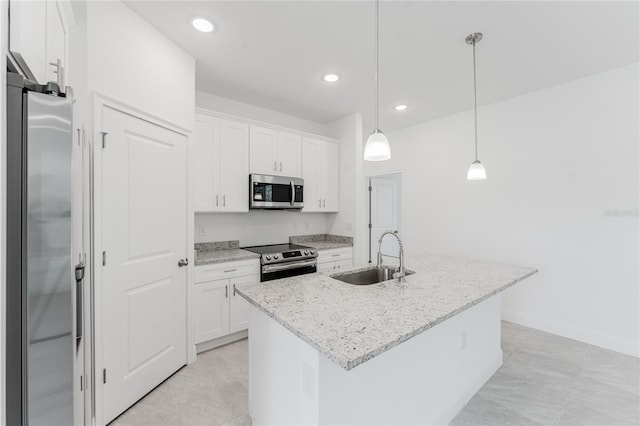 kitchen with hanging light fixtures, sink, an island with sink, white cabinetry, and appliances with stainless steel finishes