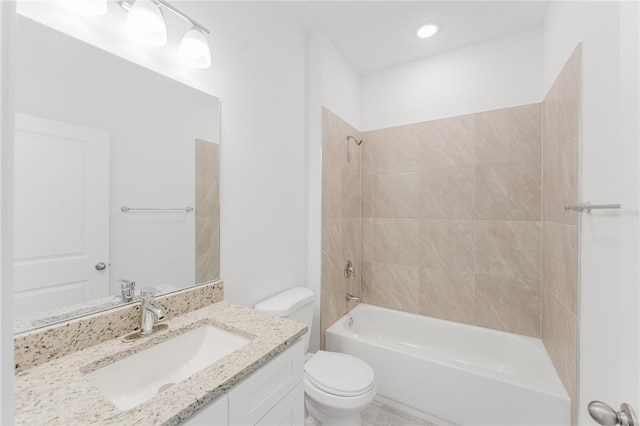 full bathroom with tiled shower / bath, toilet, and vanity