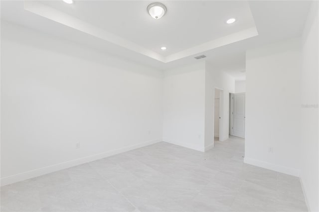 unfurnished room featuring a tray ceiling