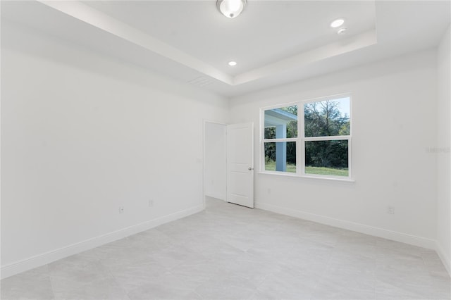 unfurnished room featuring a raised ceiling