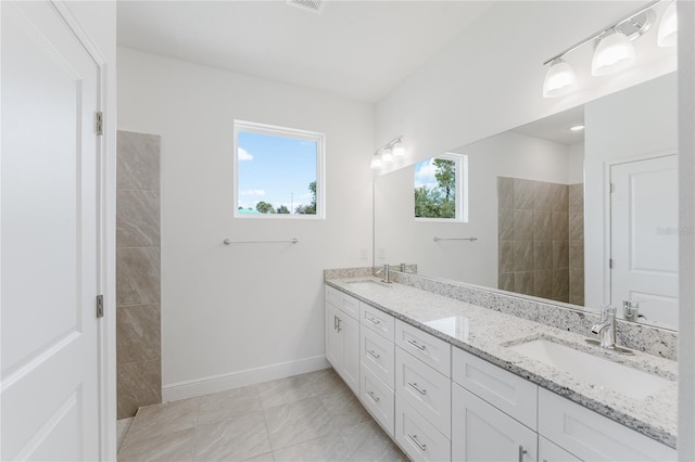 bathroom featuring vanity, tile patterned floors, and a tile shower