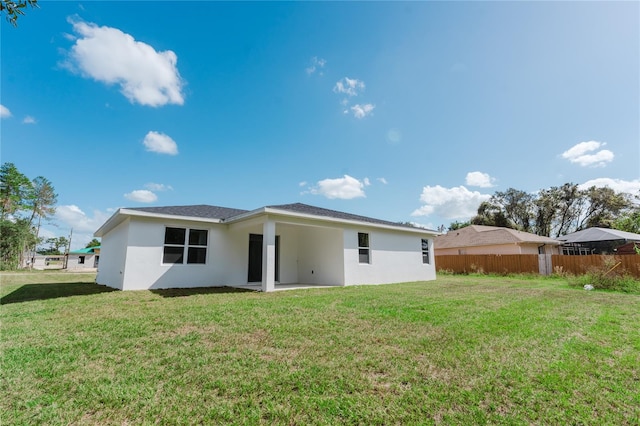 rear view of property with a yard