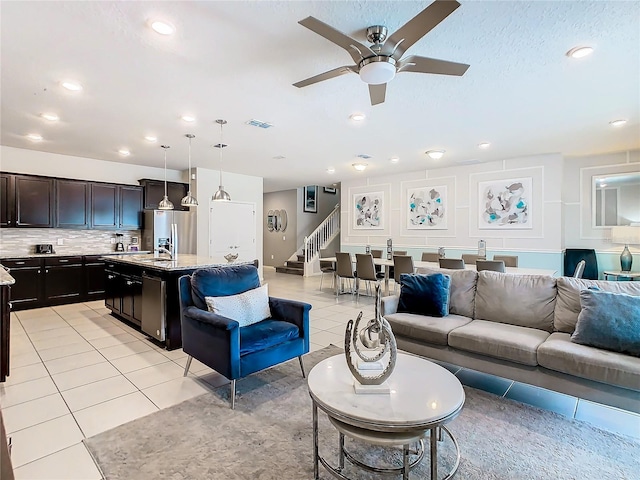 tiled living room with ceiling fan and sink