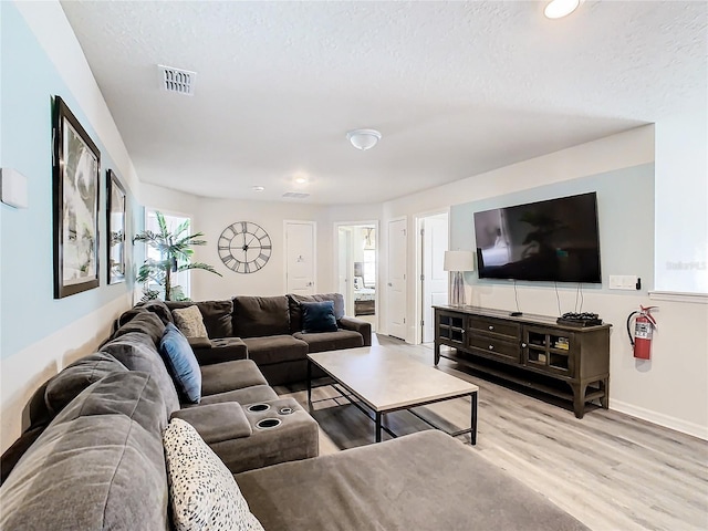 living room with light hardwood / wood-style floors and a textured ceiling