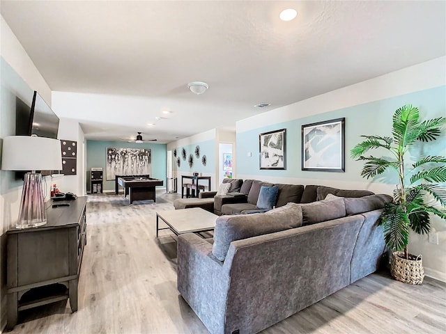 living room with ceiling fan and light wood-type flooring