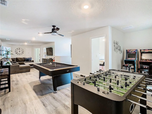 recreation room with a textured ceiling, ceiling fan, billiards, and light hardwood / wood-style flooring