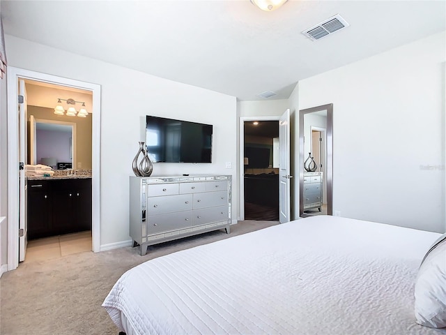 bedroom featuring light colored carpet and ensuite bathroom