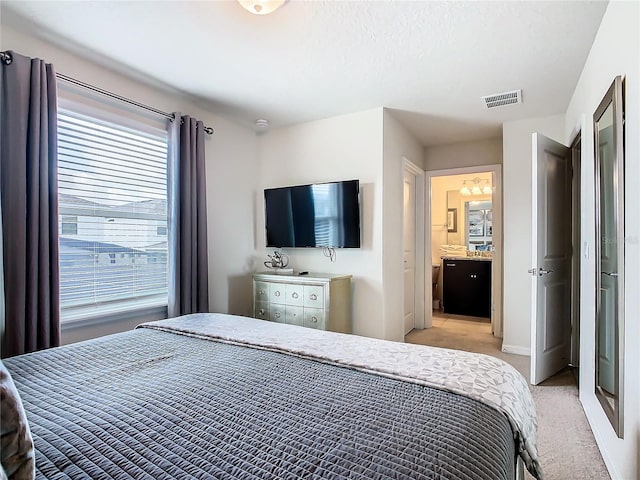 carpeted bedroom with ensuite bath