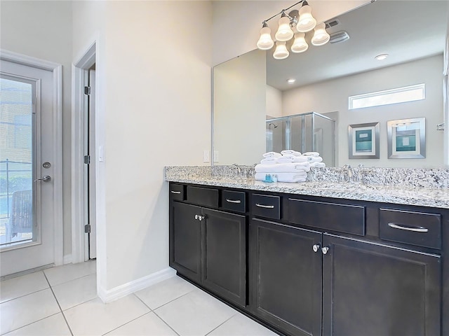 bathroom featuring vanity, a chandelier, tile patterned floors, and a shower with shower door