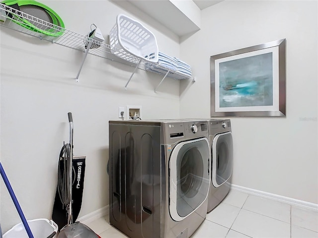 washroom with light tile patterned floors and washer and clothes dryer