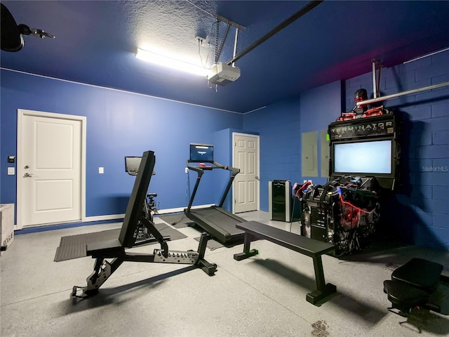 exercise area with a textured ceiling and electric panel