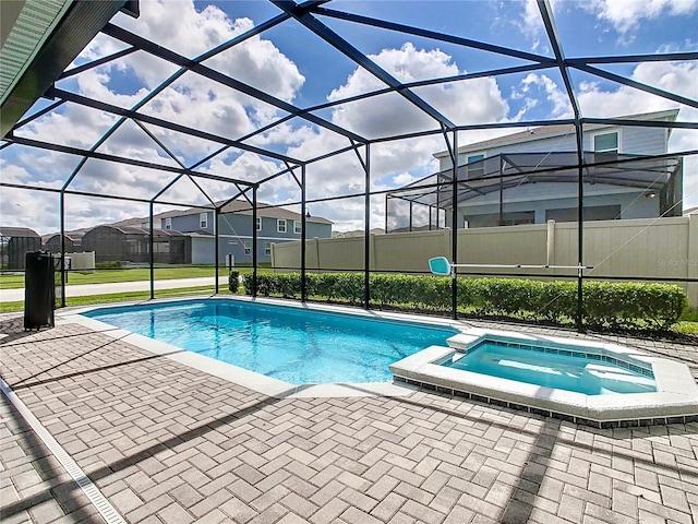 view of swimming pool with a patio, an in ground hot tub, and a lanai