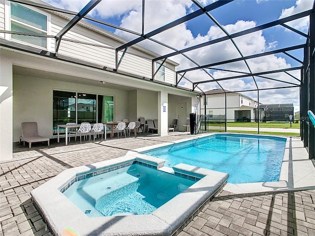 view of pool featuring a lanai, an in ground hot tub, and a patio area