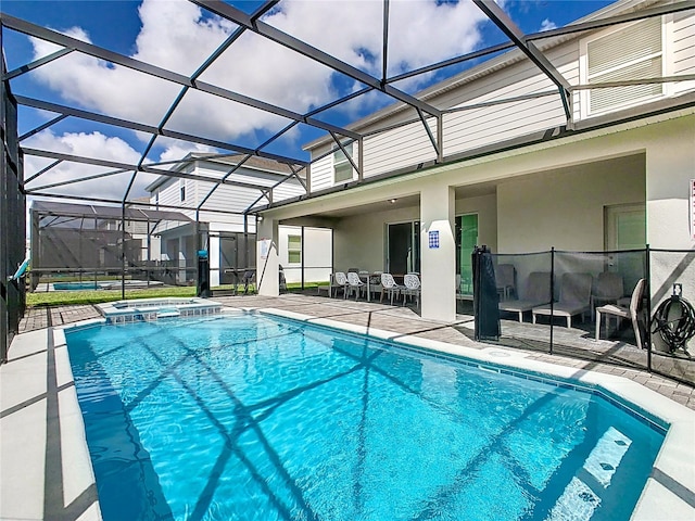 view of pool with a patio, an in ground hot tub, and a lanai