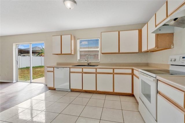 kitchen with white cabinets, white appliances, sink, and light tile patterned floors