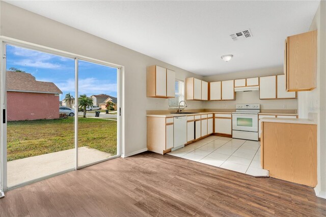 kitchen featuring white appliances, sink, and light wood-type flooring