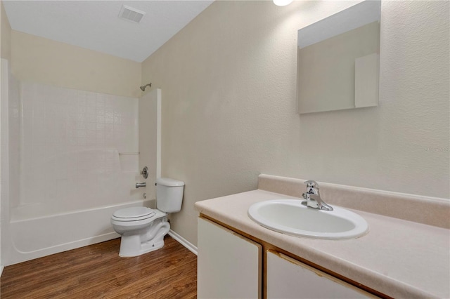 full bathroom featuring vanity, hardwood / wood-style floors, washtub / shower combination, and toilet