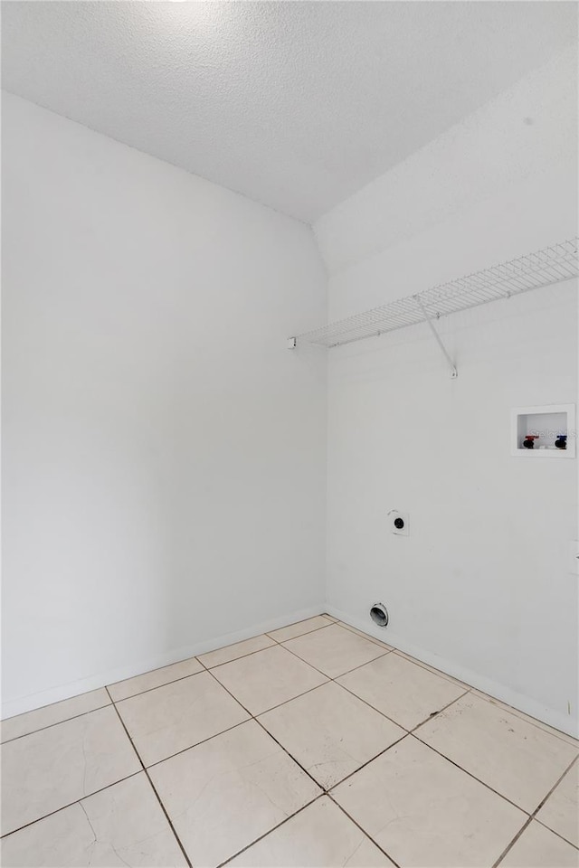 washroom featuring light tile patterned floors, hookup for a washing machine, hookup for an electric dryer, and a textured ceiling