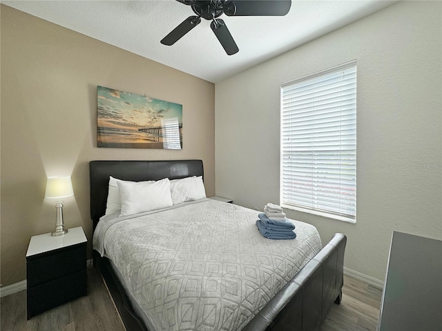 bedroom featuring multiple windows, ceiling fan, and hardwood / wood-style flooring