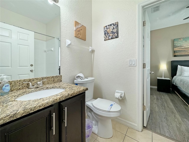 bathroom with wood-type flooring, vanity, toilet, and a shower