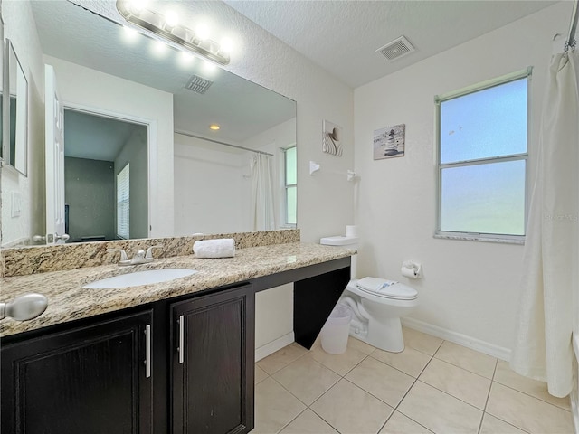 bathroom featuring a textured ceiling, vanity, toilet, and tile patterned floors