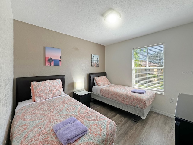 bedroom featuring a textured ceiling and dark wood-type flooring