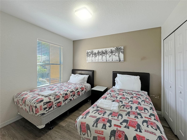 bedroom featuring a closet, dark hardwood / wood-style floors, and a textured ceiling