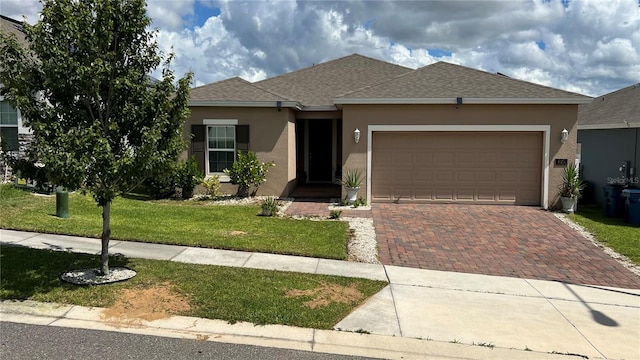 view of front of home with a front yard and a garage