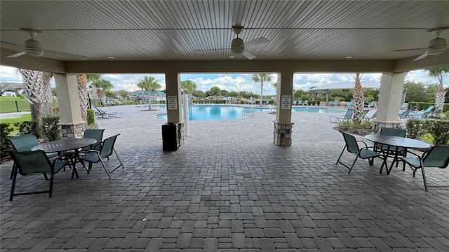 view of patio with ceiling fan and a community pool