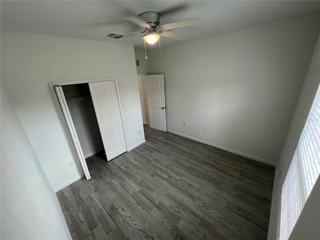 unfurnished bedroom featuring dark hardwood / wood-style flooring, a closet, vaulted ceiling, and ceiling fan